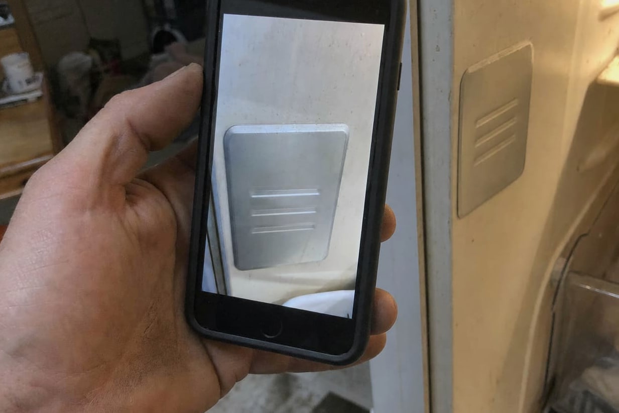 Phone photograph of a Sub-Zero model and serial plate inside the fresh-food compartment